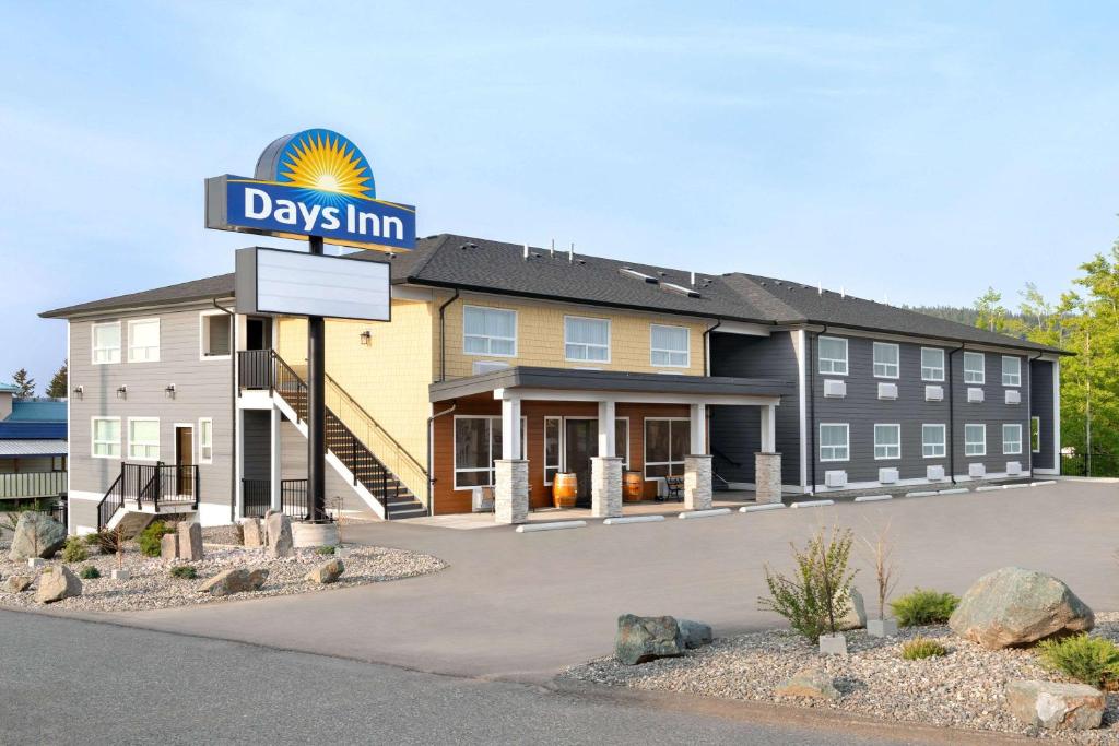 a hotel with a sign in front of a building at Days Inn by Wyndham 100 Mile House in One Hundred Mile House