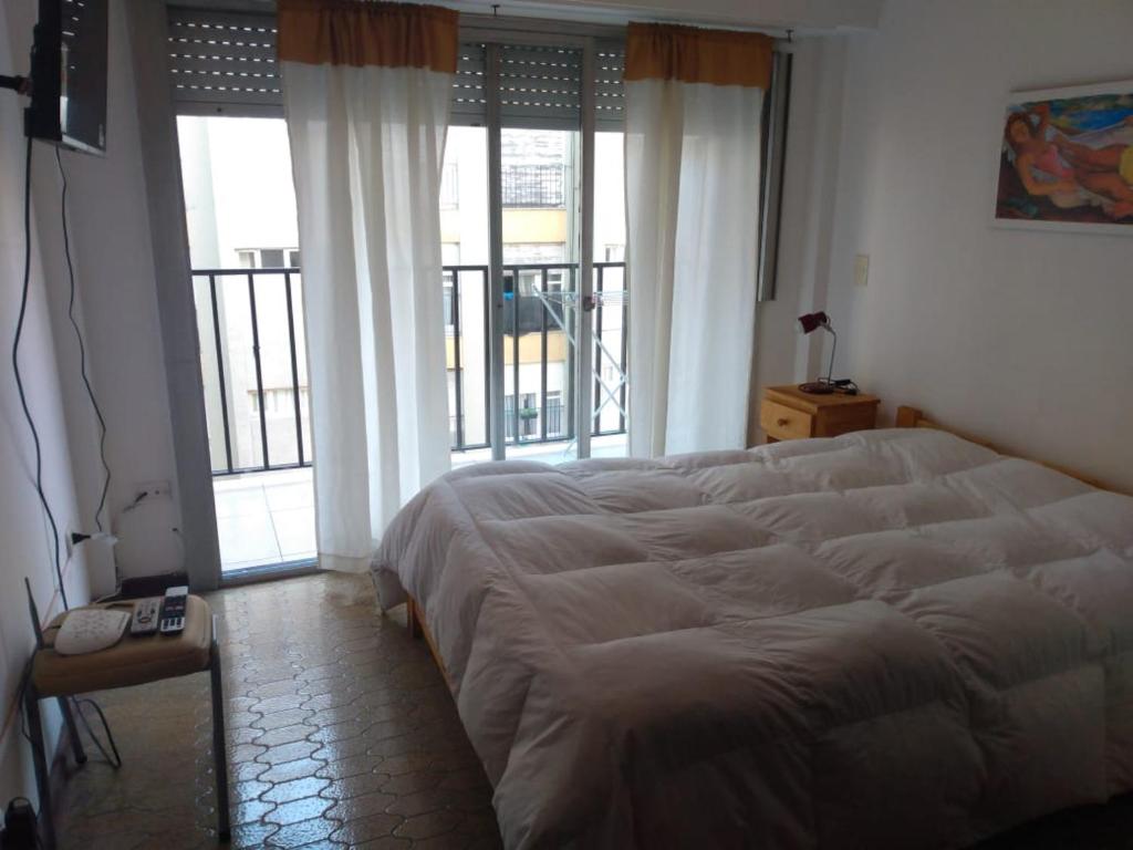 1 dormitorio con 1 cama grande y ventanas grandes en DPTO VICTORIA II en Mar del Plata