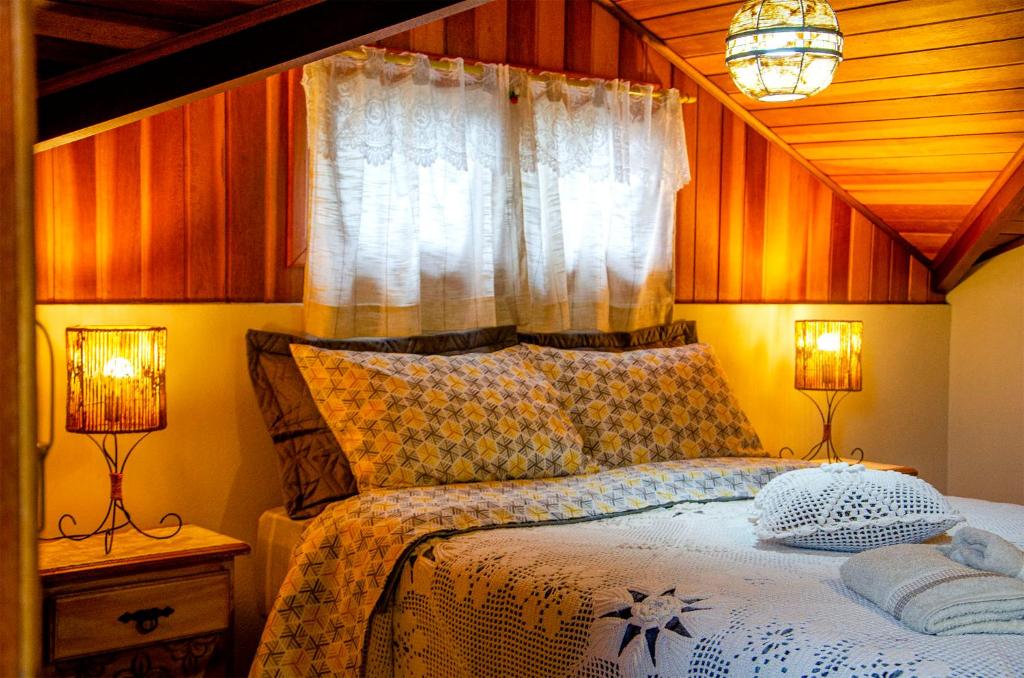 una camera da letto con un letto con due lampade e una finestra di Cantinho Pedra da Gávea a Visconde De Maua