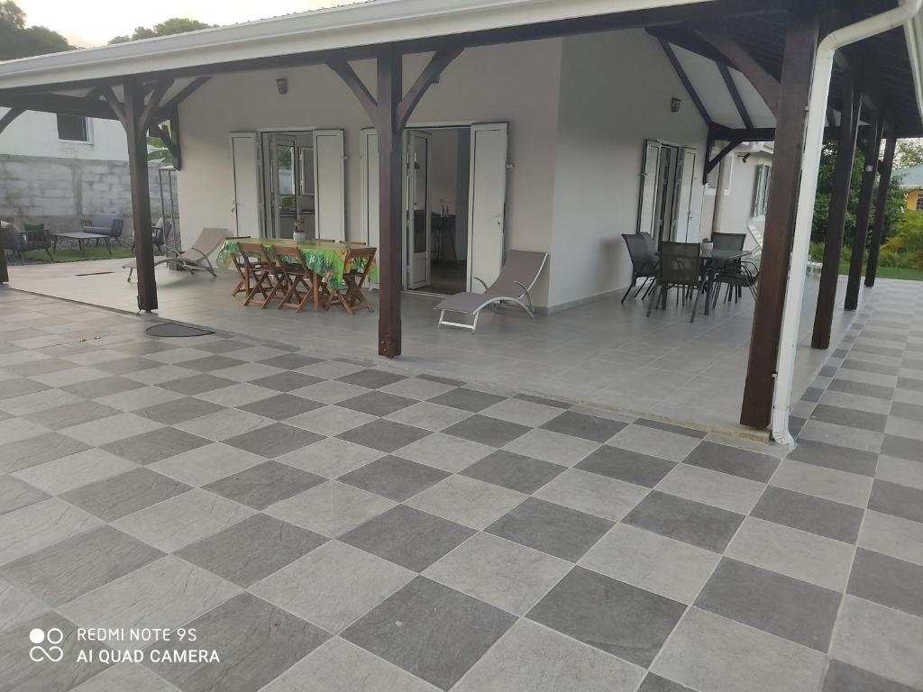 an outdoor patio with a checkered floor and chairs at VILLA GLYCIRIDIA in Le Vauclin