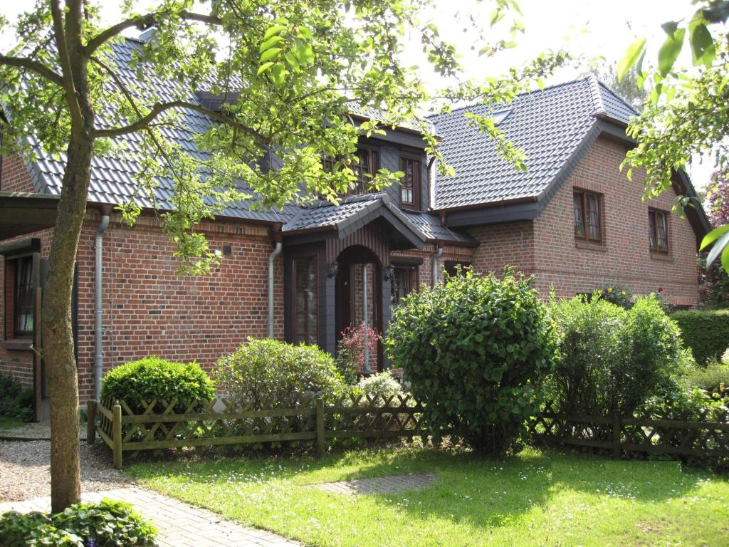a brick house with a fence in front of it at "Im Eichenhof" Whg 1 - idyllische Dorflage Nähe Grömitz! Jetzt mit WLAN! in Schashagen