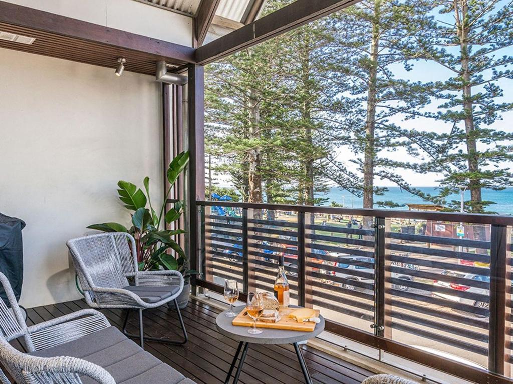 a balcony with a table and chairs and a view of the water at On The Bay II in Byron Bay