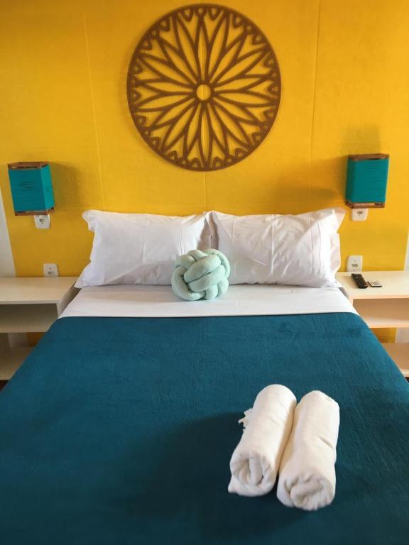 a bedroom with a bed with towels on it at Pousada Astral in Imbituba