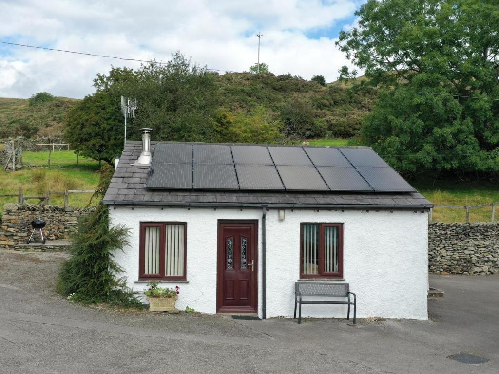 a small house with solar panels on the roof at Ghyll Bank Bungalow in Staveley