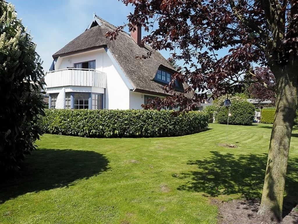 a white house with a thatched roof and a yard at Ferienhaus Weinhardt - Whg 2 in Zingst