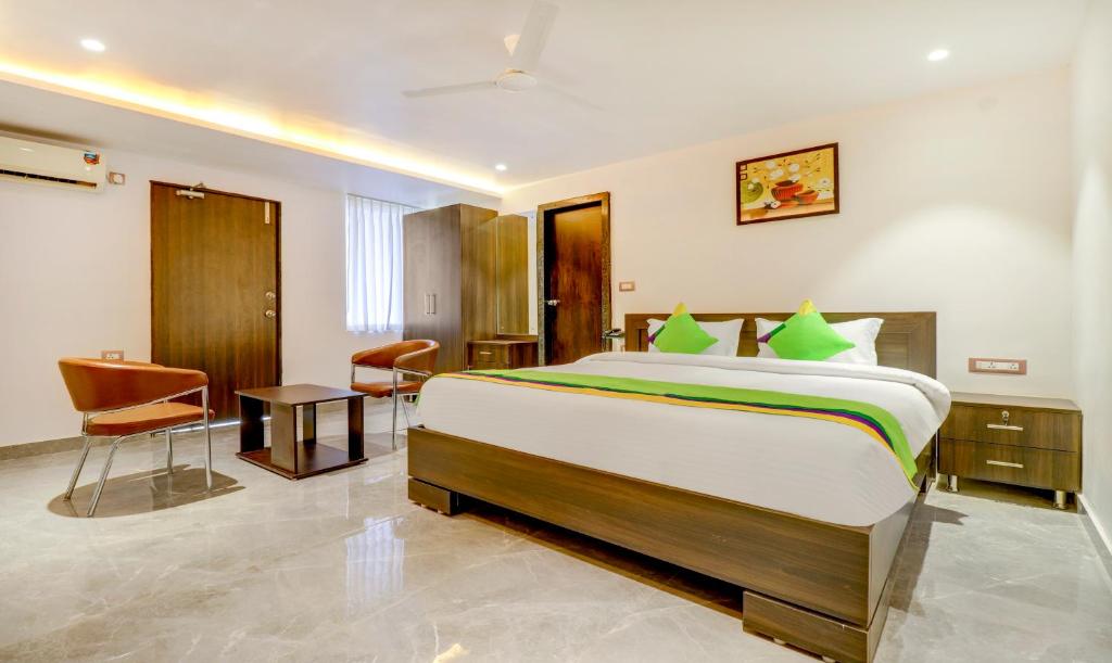 a hotel room with a large bed and a desk at Treebo Trend Siesta Muralinagar in Visakhapatnam