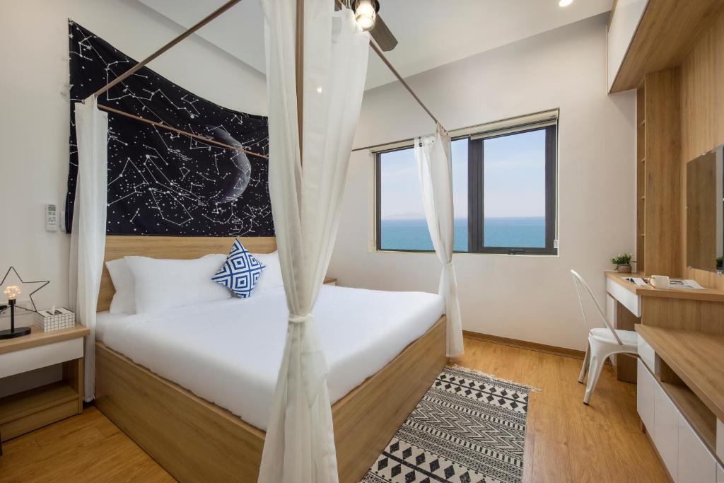 a bedroom with a bed with a mosquito net at Arrive Hotel & Apartment in Danang