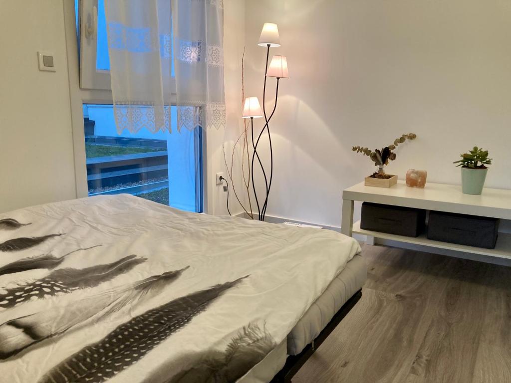 a bedroom with a bed and a table and a window at Appartement Muse proche Gare in Metz