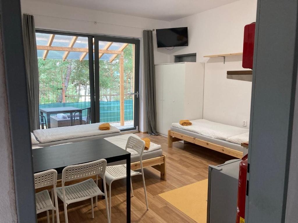 sala de estar con mesa, sillas y ventana en KuK Račice - mini apartman, en Račice