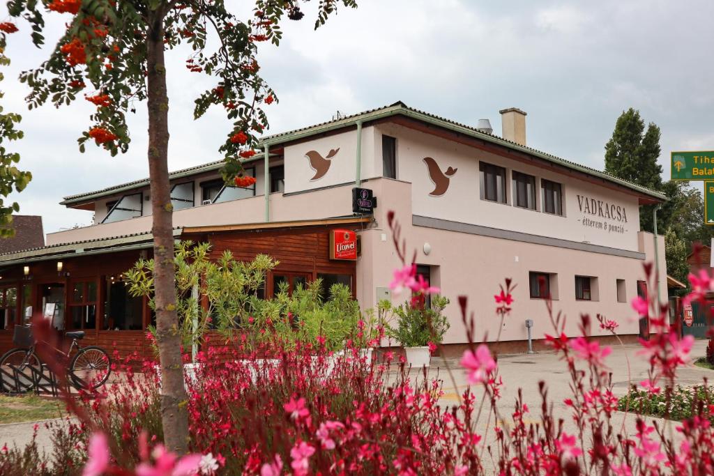 ein Gebäude mit rosa Blumen davor in der Unterkunft Vadkacsa Panzio in Balatonkenese