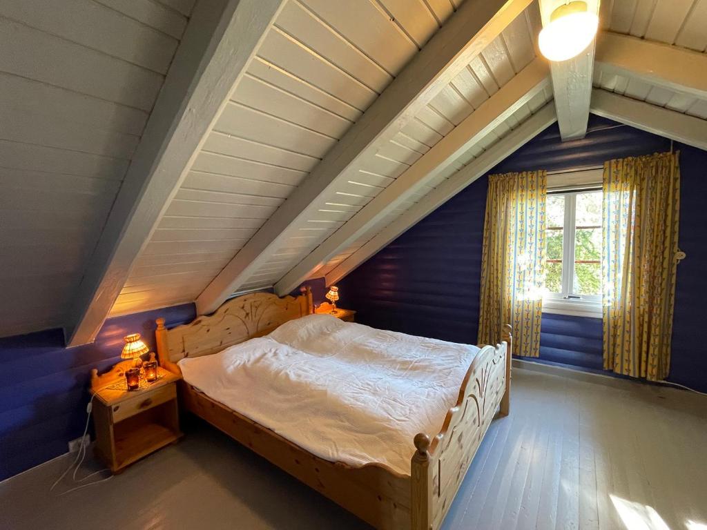um quarto com uma cama grande num sótão em Olastugu em Al