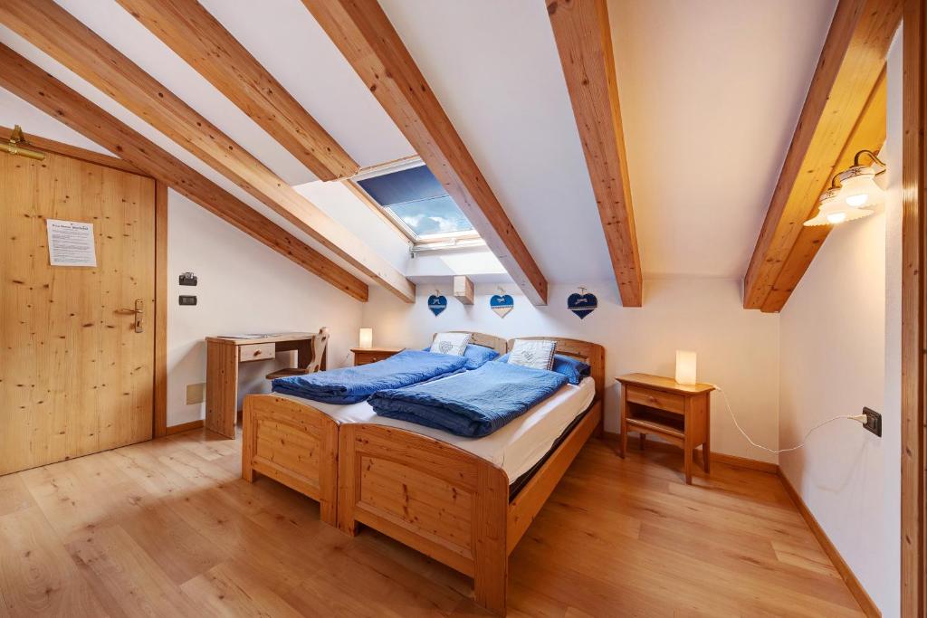 een slaapkamer met een bed in een kamer met houten plafonds bij Residence Montebel Studio in Tesero