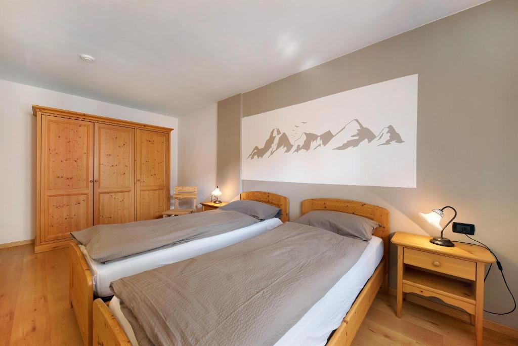 um quarto com uma cama e um quadro na parede em Residence Montebel Bilocale em Tesero