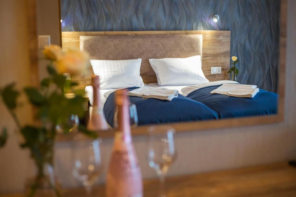 a bedroom with a bed and a table with wine glasses at Origami Prestige in Koszalin