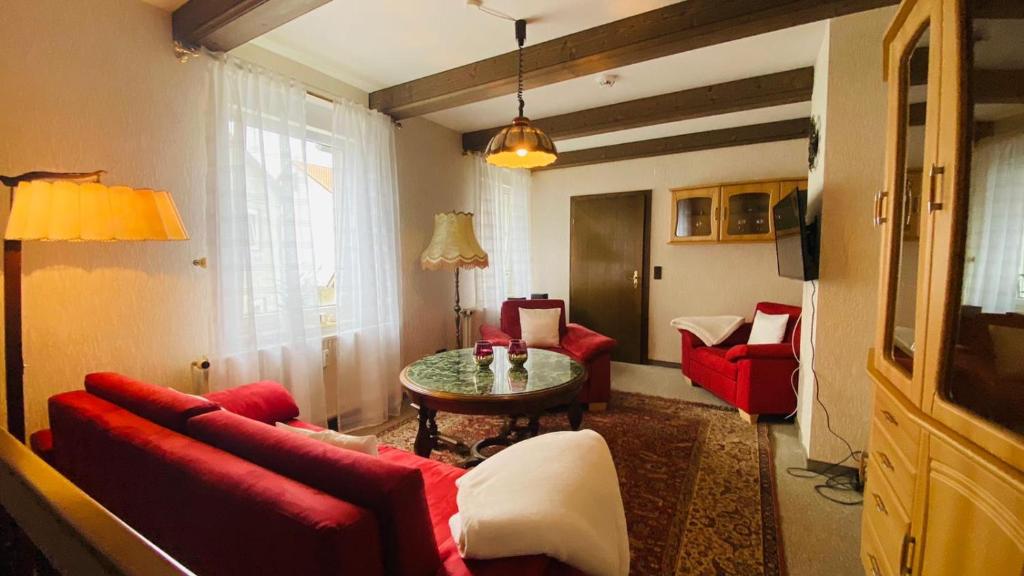 Ferienappartement Mimmi في باد لوتربرغ: غرفة معيشة مع أريكة حمراء وطاولة