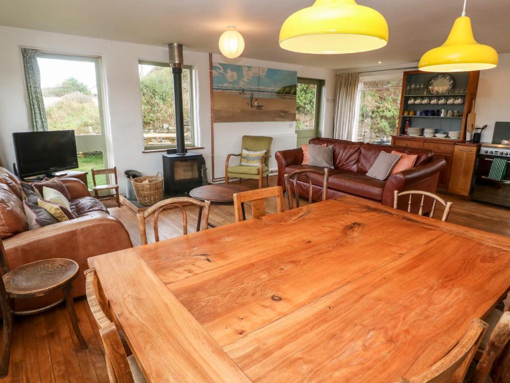 a living room with a wooden table and chairs at Porth Farm Annexe in Newquay