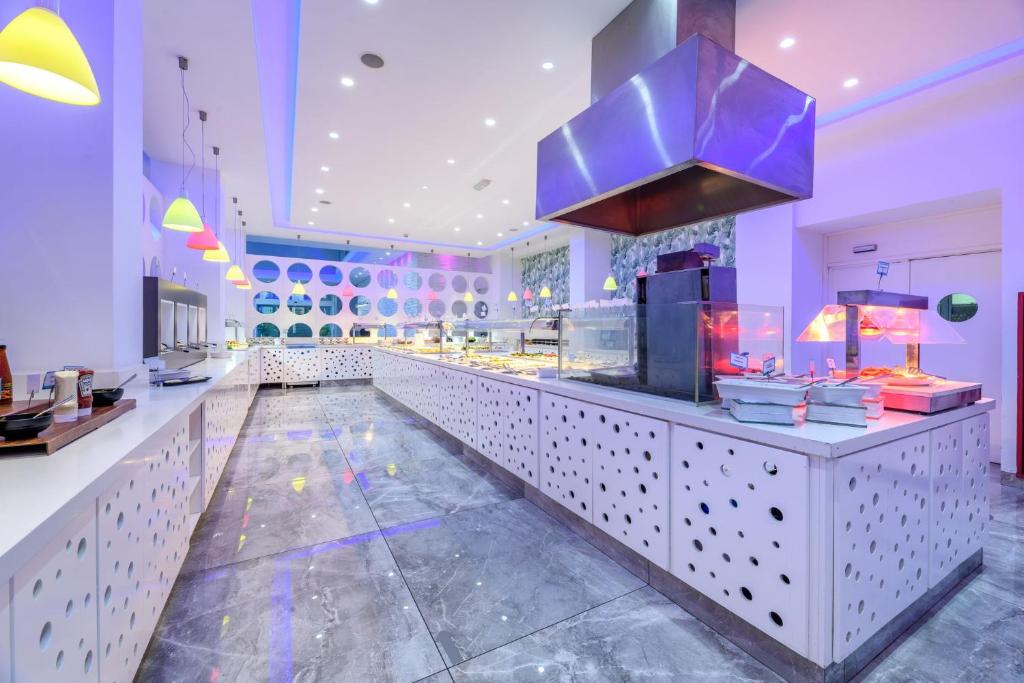 a restaurant with a counter with a blue lighting at River Rock Hotel in Ayia Napa