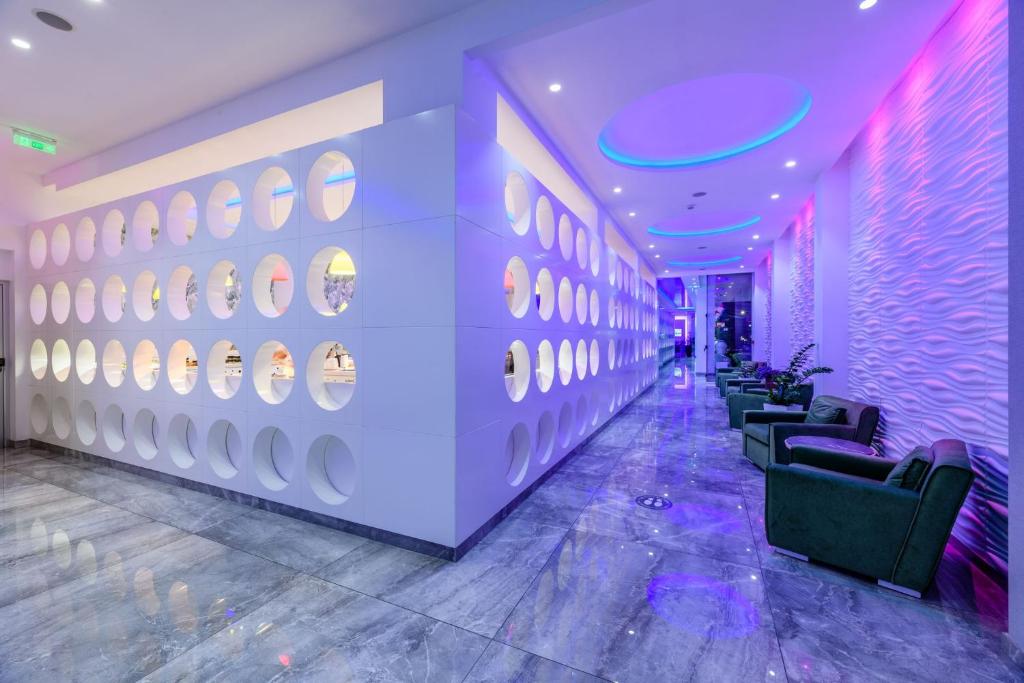 a lobby with chairs and a wall of plates at River Rock Hotel in Ayia Napa