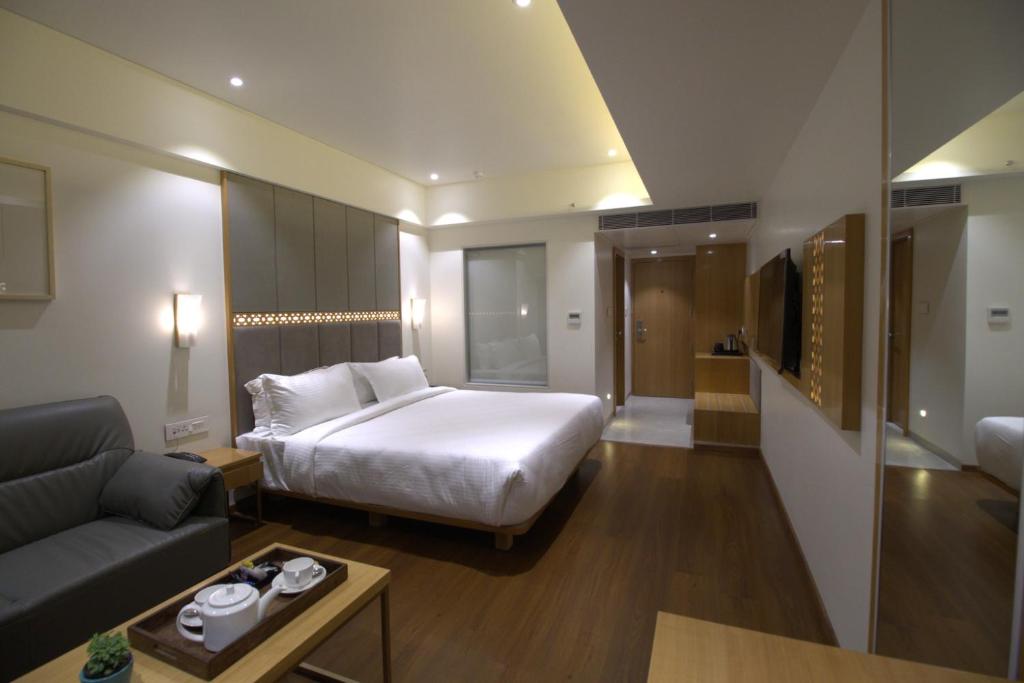 Habitación de hotel con cama y sofá en Safal Retreat, en Bhopal