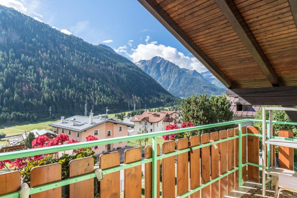 a balcony with a view of a town and mountains at Casa Vacanza Zambotti in Vermiglio
