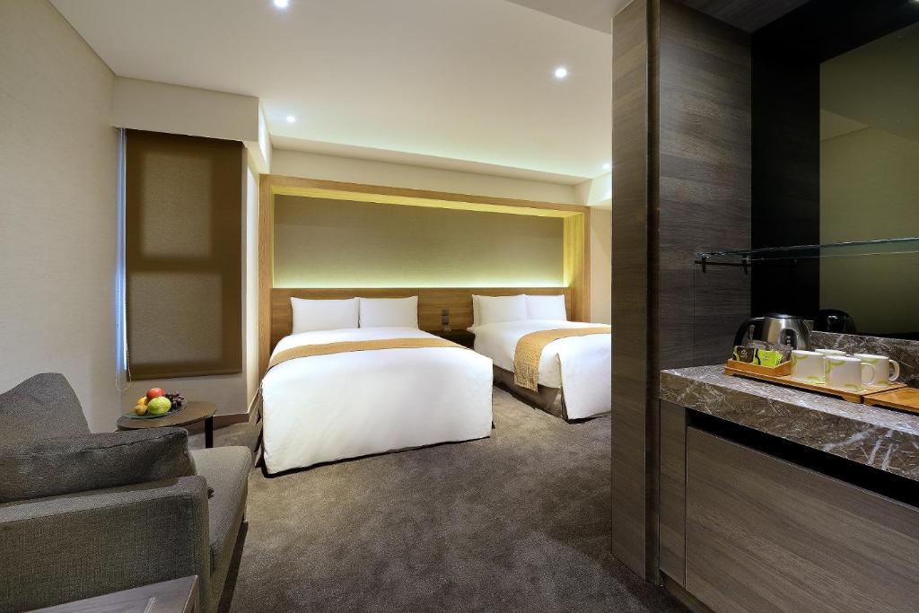 Park City Hotel - Hualien Vacation في مدينة هوالين: غرفة فندقية بسريرين ومطبخ