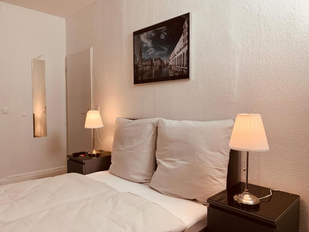 ein Schlafzimmer mit einem Bett mit Kissen und zwei Lampen in der Unterkunft Sleep In Hamburg Kajüten in Hamburg