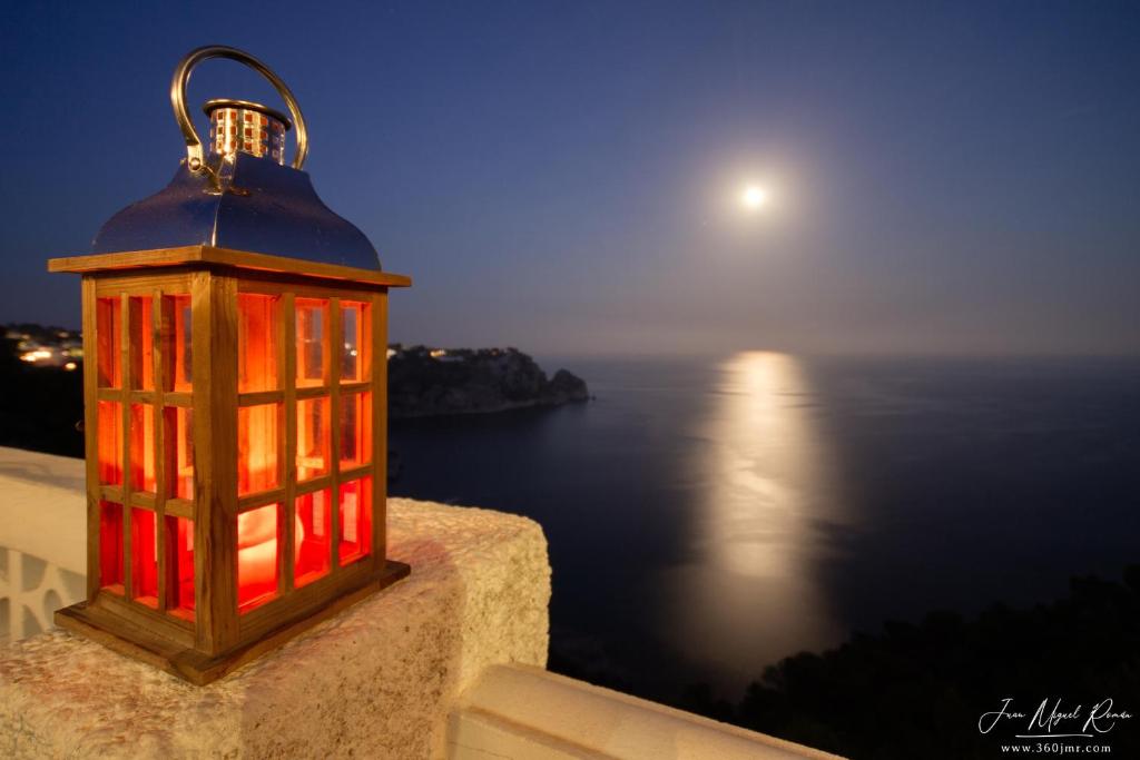 una lanterna rossa su un muro con vista sull'oceano di Sobre de Granadella Haus 3-bis a Jávea