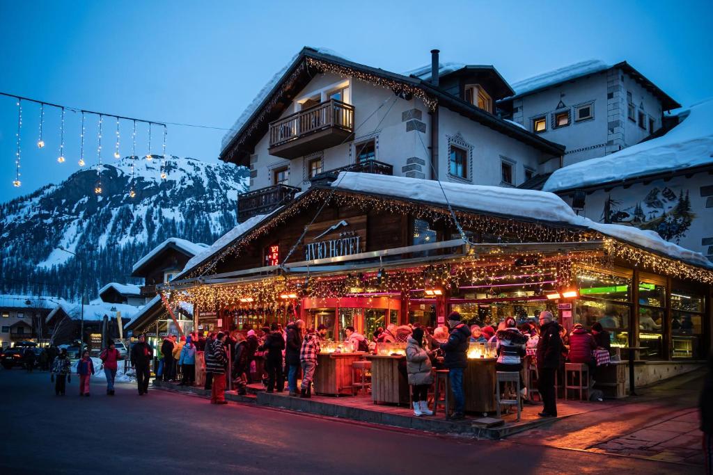 a group of people standing in front of a building with christmas lights at Bivio Hotel Plaza in Livigno