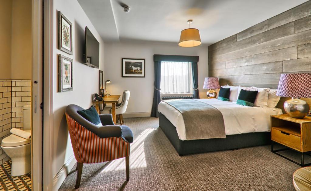 een hotelkamer met een bed en een stoel bij The Wellington Arms in Heckfield