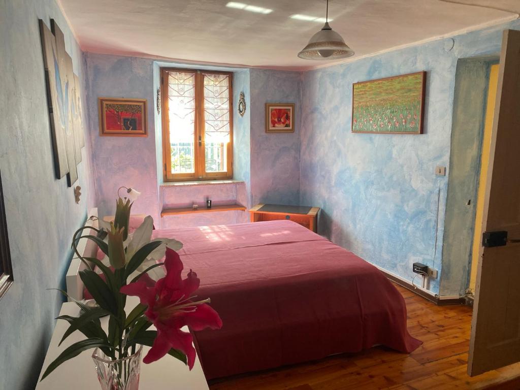 - une chambre avec un lit rouge et un vase de fleurs dans l'établissement Casa Dolce Casa, à Sarre