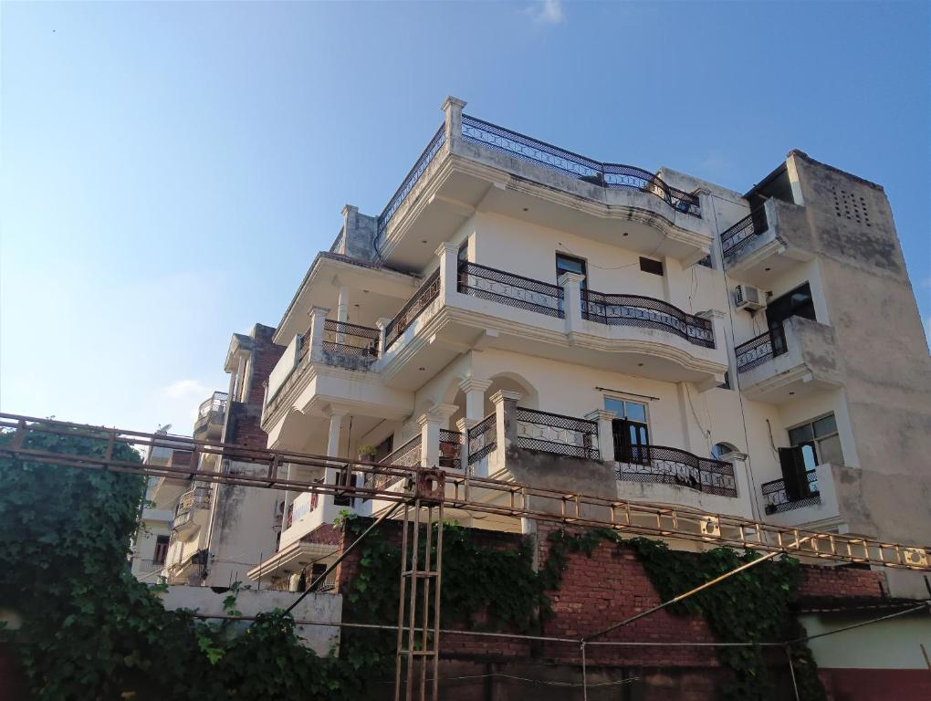 a tall white building with balconies on top of it at Varuna Palace Near Mandir & Ghat's Varanasi in Varanasi