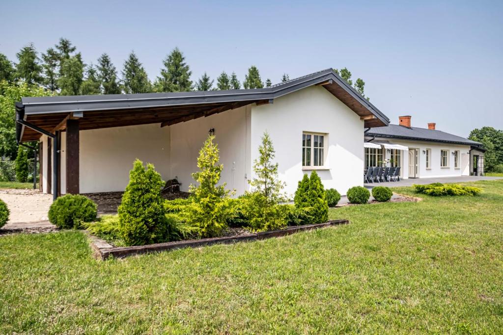 a white house with a garden in front of it at Sophie Country House in Łękawica