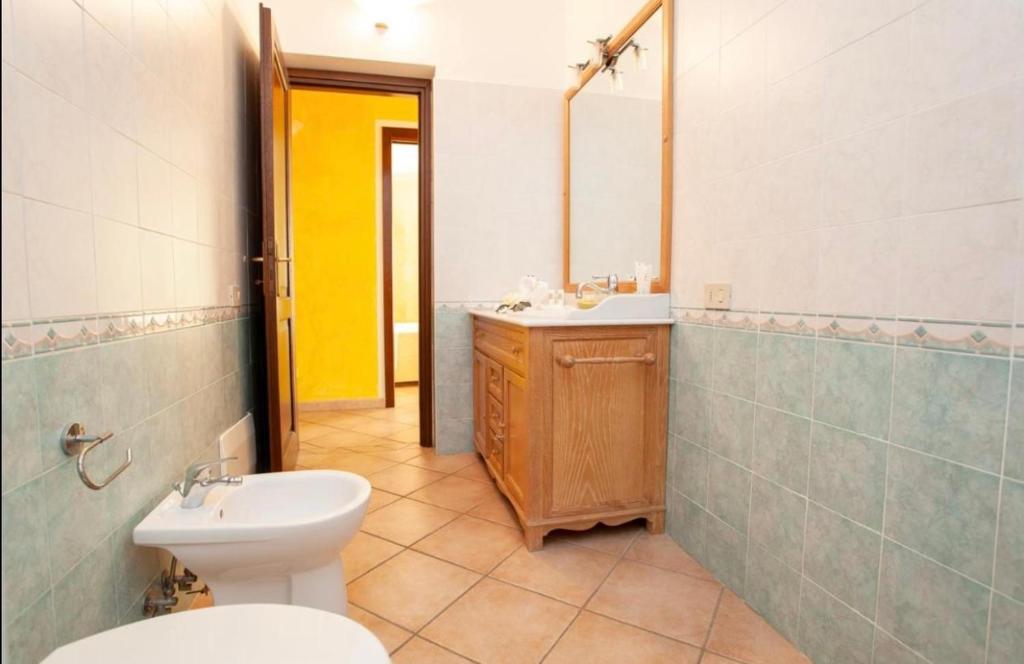 a bathroom with a toilet and a sink and a mirror at Casa Carmen - Attico vista mare in Porto San Paolo