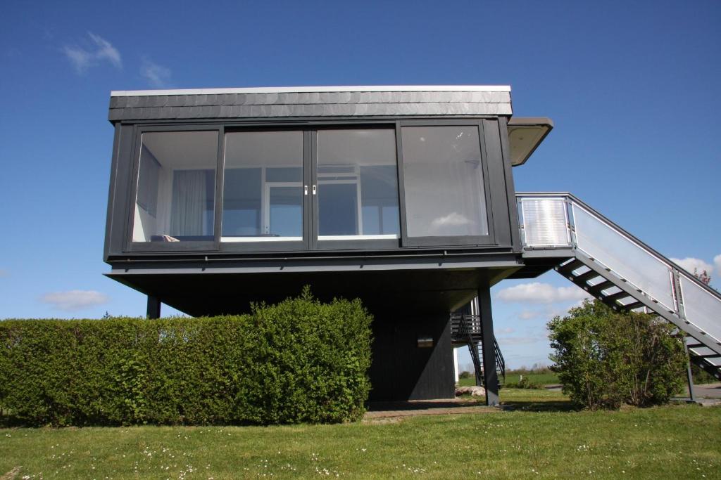 a modern house with a glass door and stairs at Ferienhaus am Ostseestrand in Großenbrode