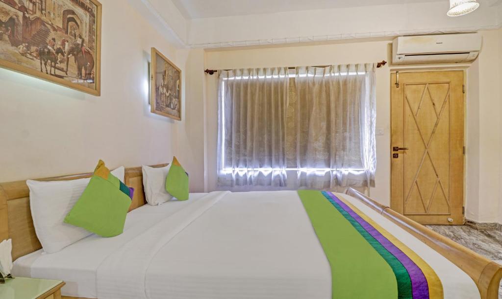 Postel nebo postele na pokoji v ubytování Treebo Komfort Suites, 3 Km From Mysore Palace