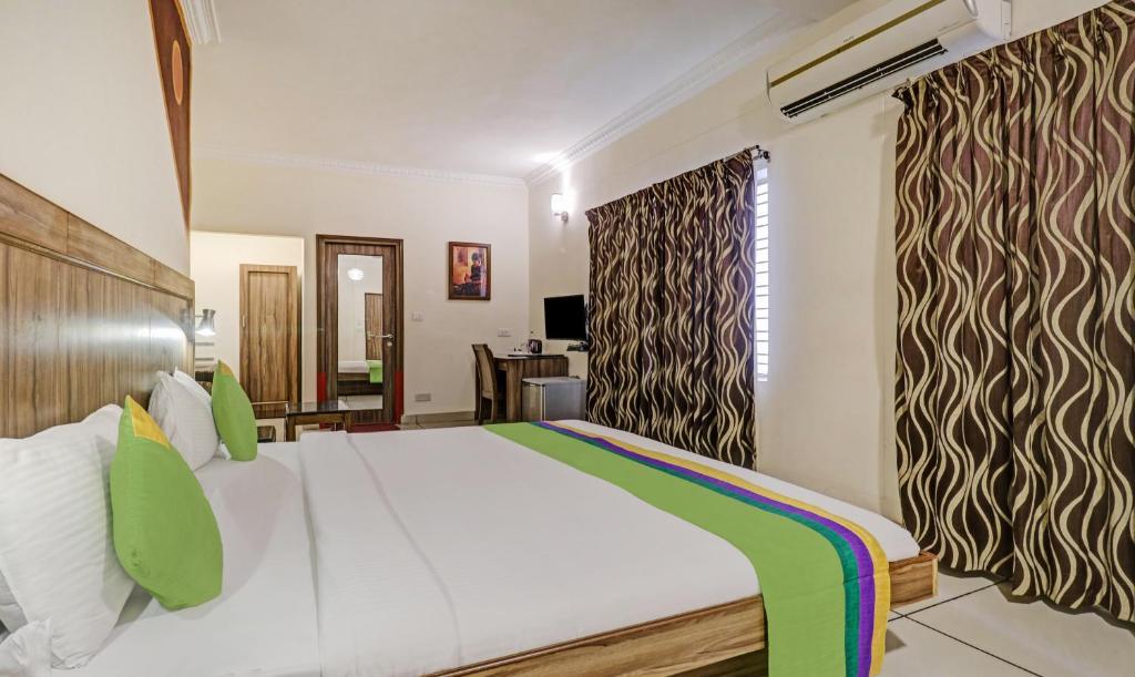 Postel nebo postele na pokoji v ubytování Treebo Komfort Suites, 3 Km From Mysore Palace