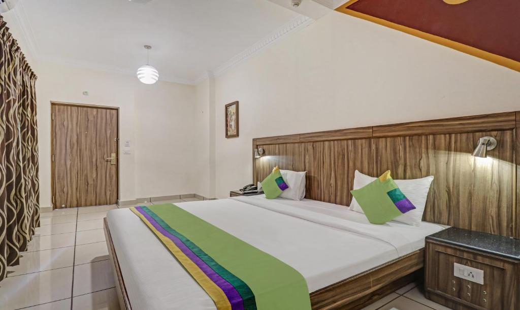 Postel nebo postele na pokoji v ubytování Treebo Komfort Suites, 3 Km From Mysore Palace