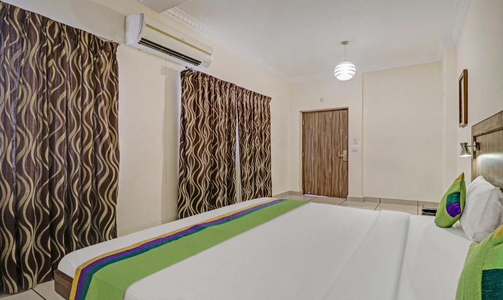 Postel nebo postele na pokoji v ubytování Treebo Komfort Suites, 3 Km From Mysore Palace