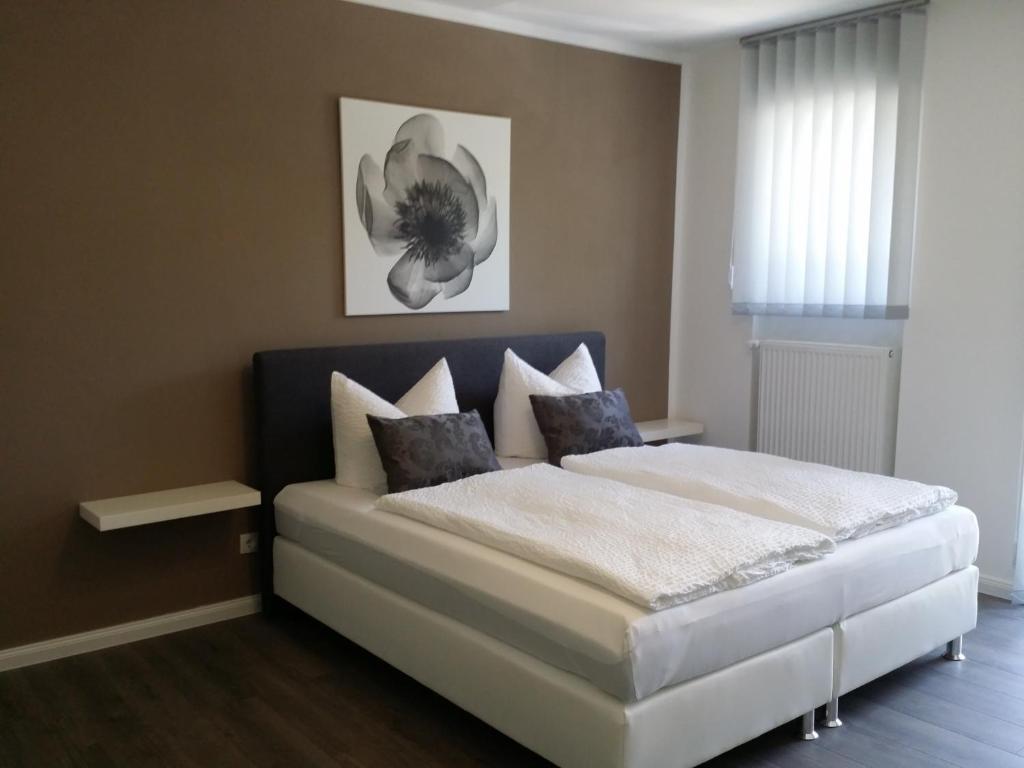 a bedroom with a large white bed with pillows at HD City Apartments in Heidelberg