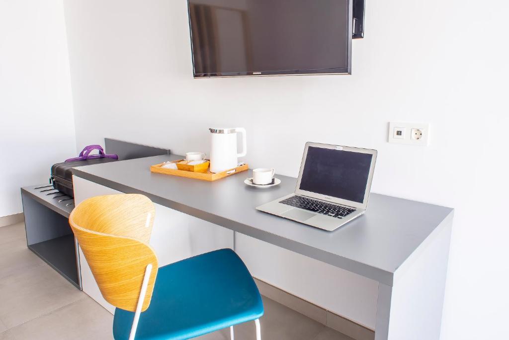 a laptop computer sitting on a desk with a chair at Hotel Taimar in Costa Calma