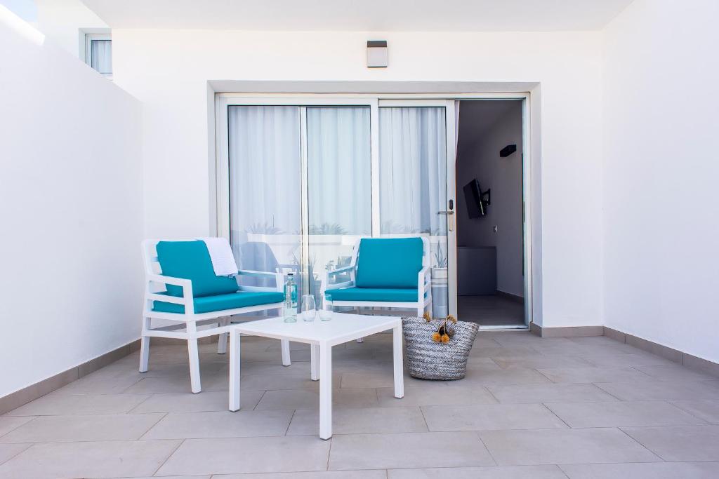 two blue chairs and a table on a balcony at Hotel Taimar in Costa Calma