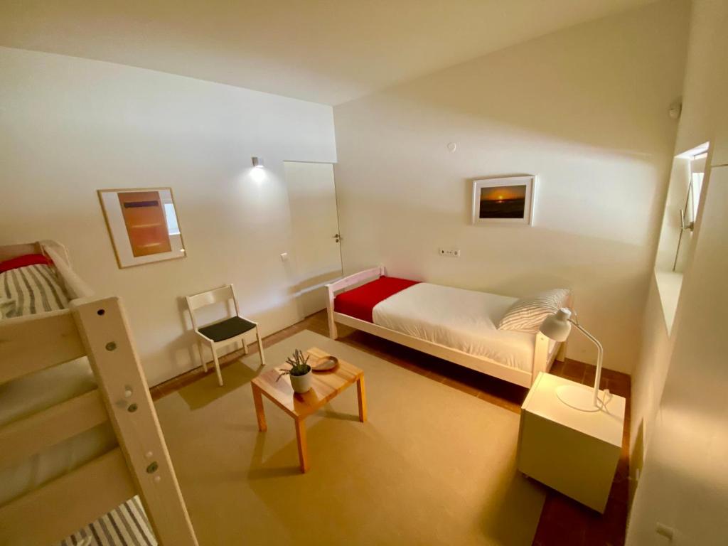 a small bedroom with a bed and a table at Bernardas Convent Apartment in Tavira