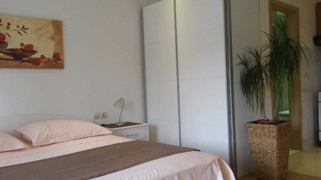 a bedroom with a bed and a potted plant at Apartments Jani in Hvar