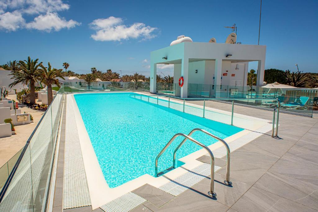 a swimming pool with a large swimming pool next to a building at Hotel Cooee Taimar in Costa Calma