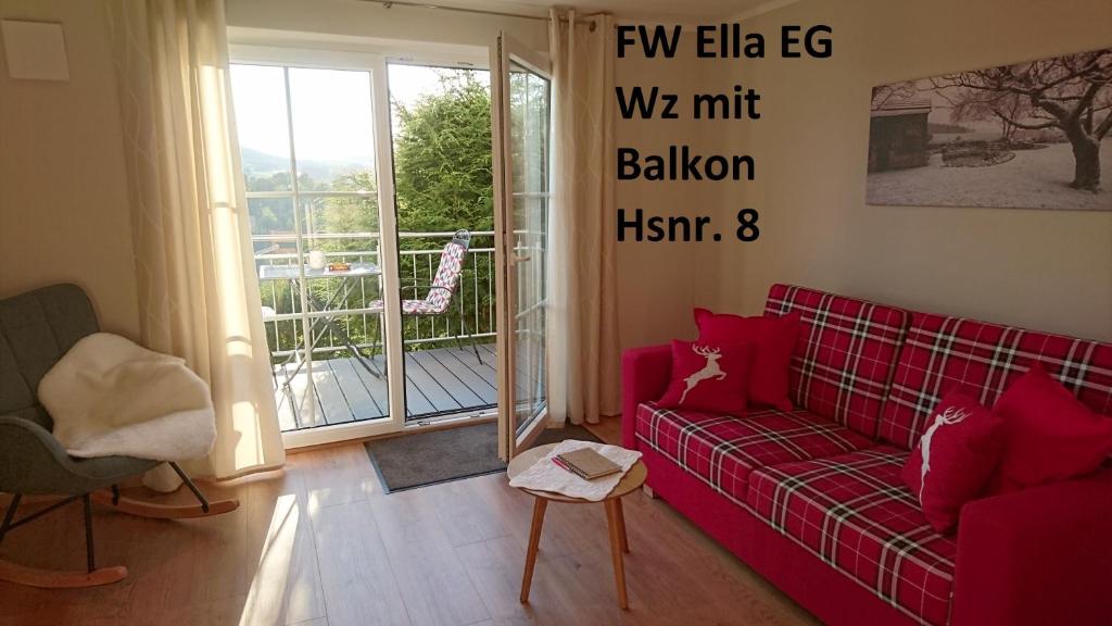 a living room with a red couch and a balcony at Ferienwohnung Rettinger in Windischeschenbach