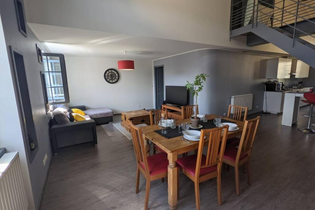 Superbe appartement duplex en hyper centre في لو بوي: غرفة طعام وغرفة معيشة مع طاولة وكراسي