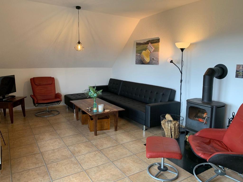 sala de estar con sofá y estufa de leña en Ferienwohnung Lix direkt am Waldrand, en Frankenau
