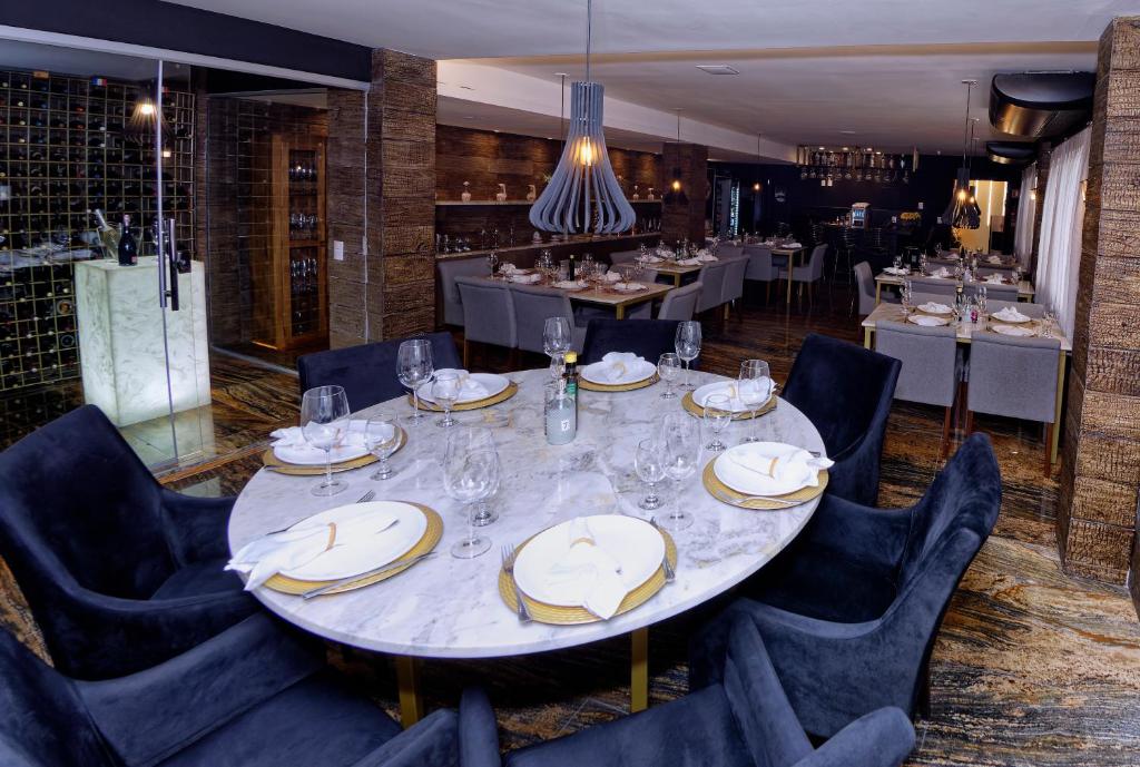 a dining room with a large white table and chairs at Hotel Sao Miguel in Collatina