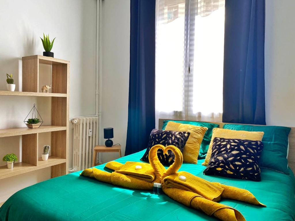 a green bed with two large yellow towels on it at Studio Design Plage des Catalans in Marseille