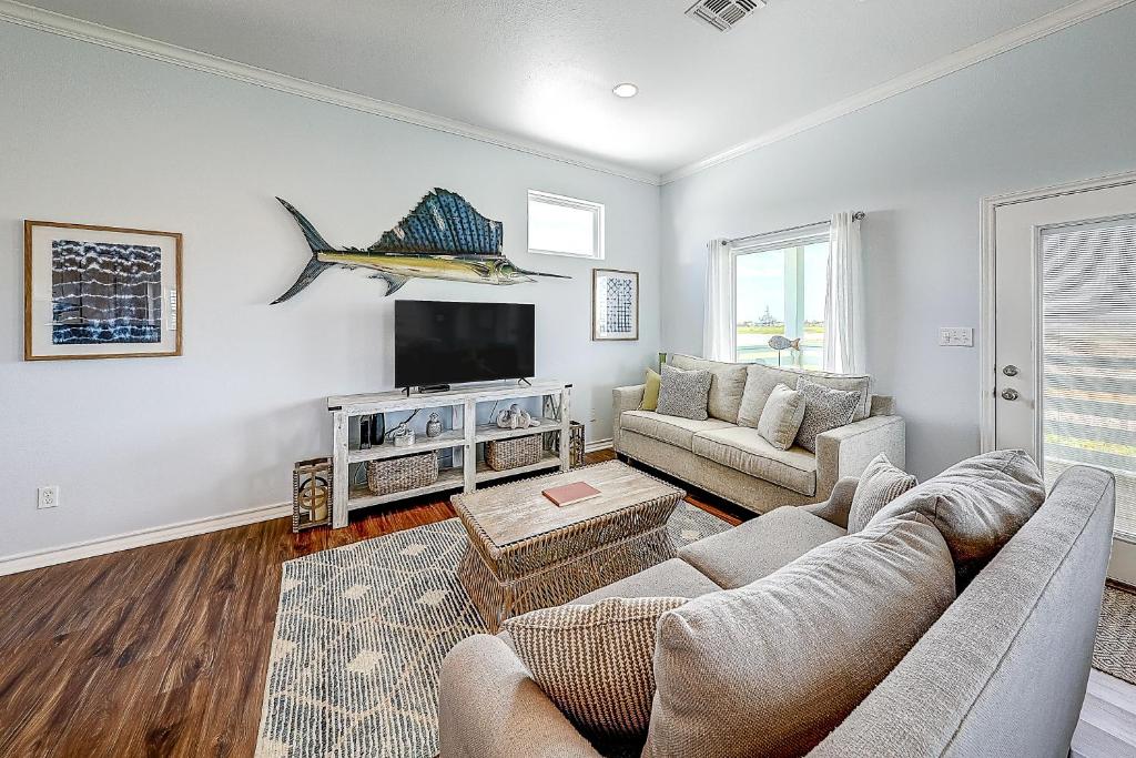 a living room with a couch and a flat screen tv at Paradise Pointe in Port Aransas